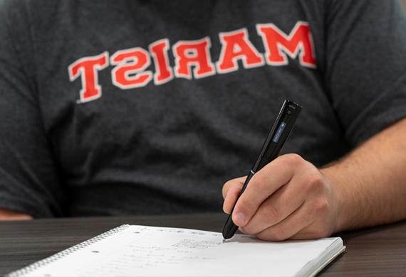 图为一名学生用钢笔在笔记本纸上写字.