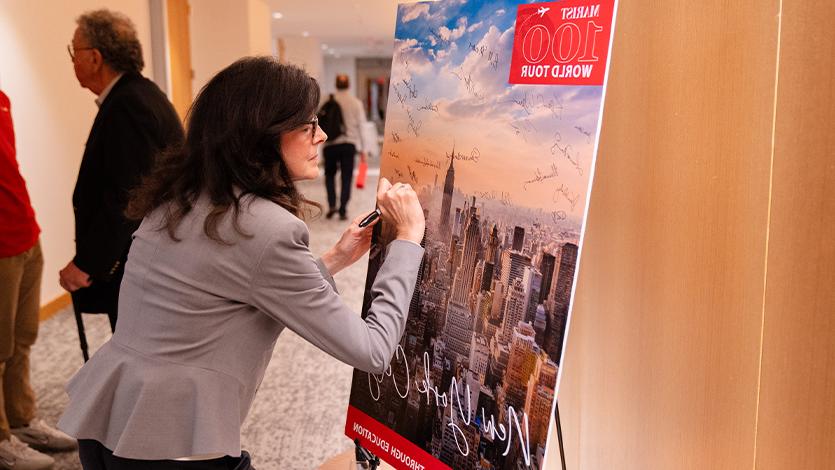 Image of attendee signing the bet亚洲365欢迎投注100 poster.