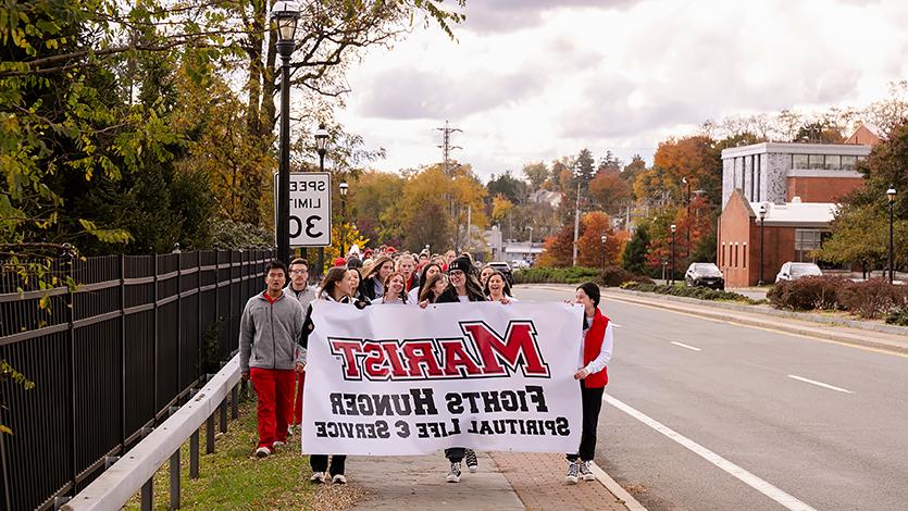 饥饿步行的参与者在9号公路上举着牌子.
